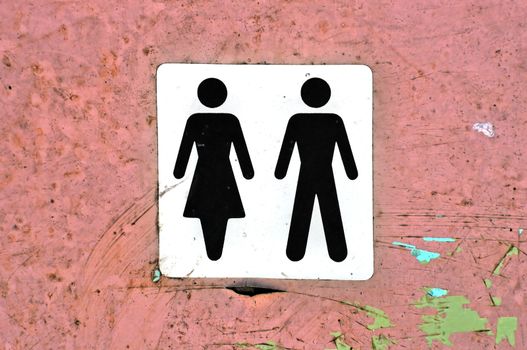 Male female symbol label on grungy wood background texture.