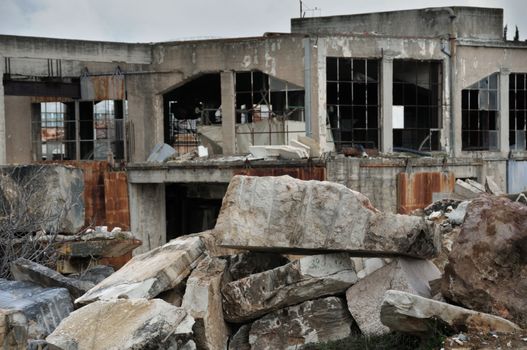 Abandoned marble processing factory and pile of granite slates. Industrial ruins.