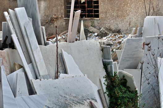 Pieces of broken marble in the yard of an abandoned processing factory.