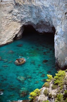 Panoramic view of rocky blue water beach and cave in Keri, Zakynthos, Greece.