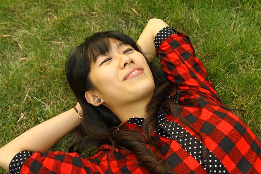 Asian woman sleeping on the grass and very relax