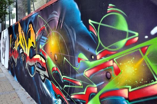 Wall surface covered with colorful graffiti. Urban street art.