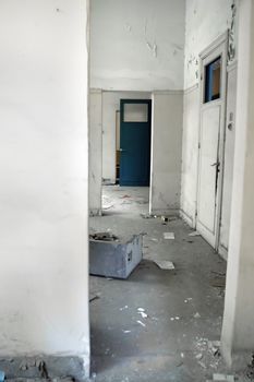 White hallway and doors in empty abandoned building.