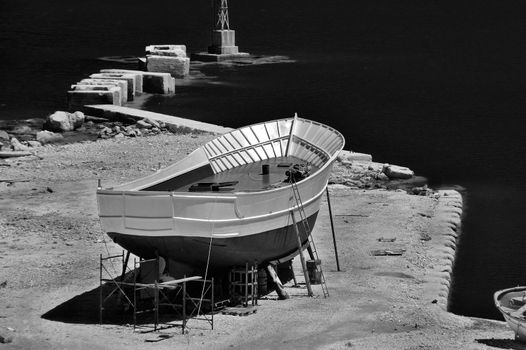 Wooden boat at shipyard in the harbor of Zakynthos, Greece. Black and white.