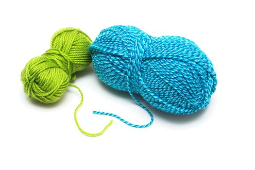 Clews of blue and green wool threads for knitting isolated