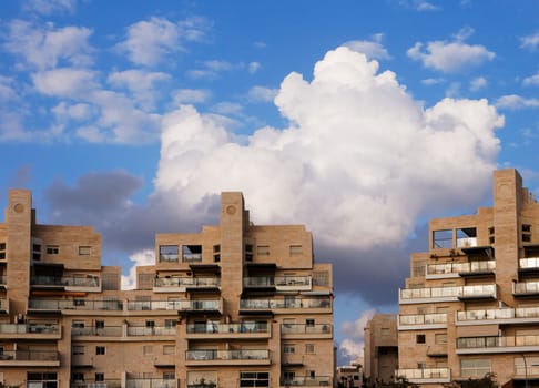 New apartment buildings and clouds above them at sunset