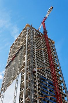 Lifting crane and high building under construction 