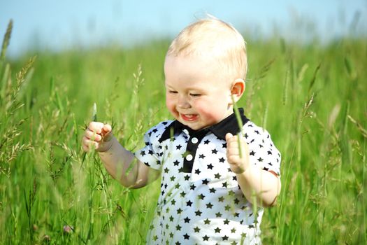 little boy play in green grass