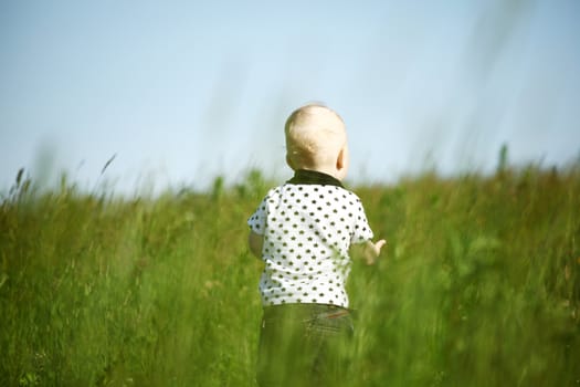  little boy play in green grass with green ball