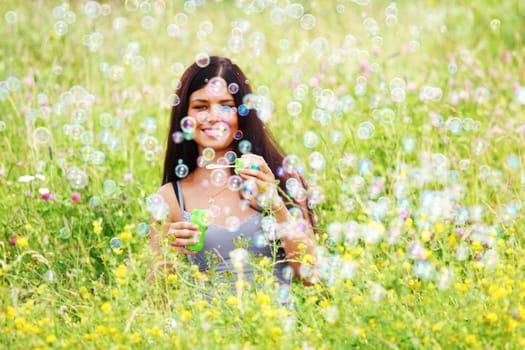  happy woman smile in green grass soap bubbles around