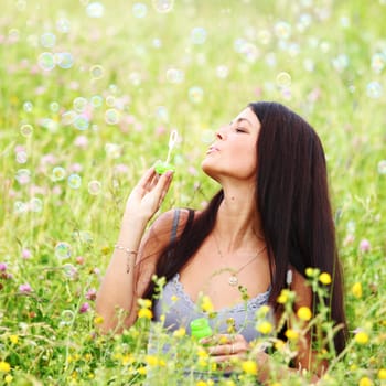  happy woman smile in green grass soap bubbles around