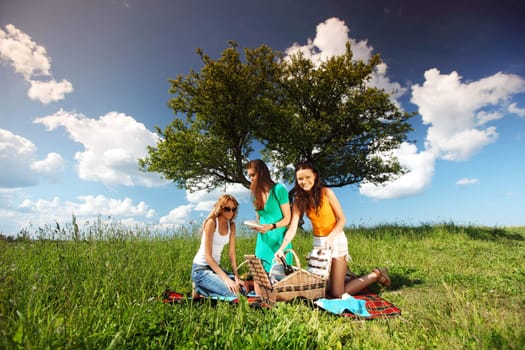 girlfriends on picnic in green grass