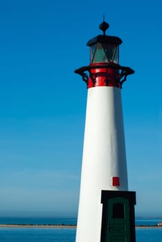 Small old red and white lighthouse by the sea