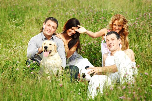 friends and dog in green grass field