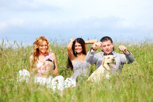 friends and dog in green grass field