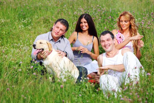 friends and dog in green grass field