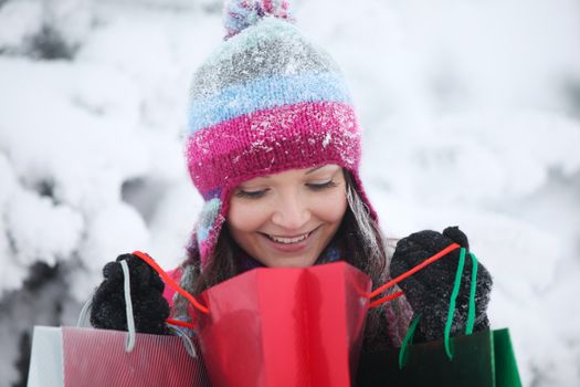 winter girl with gift bags on snow background