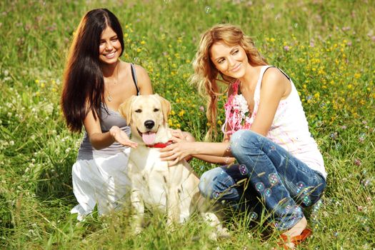 girlfriends and dog in green grass field