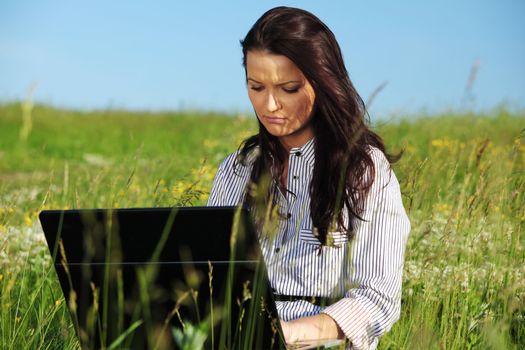 girl with laptop on green grass