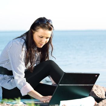 woman with laptop sea background