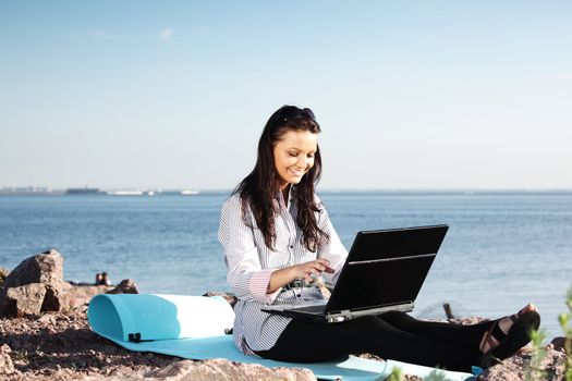 woman with laptop sea background