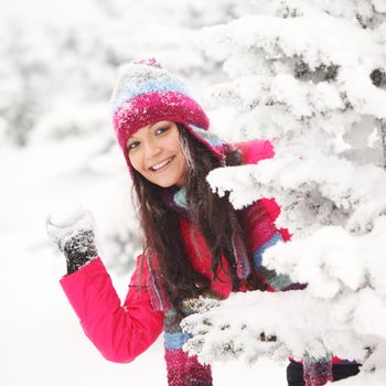 winter woman play snowballs on snow background