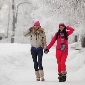 two winter women run by snow frosted alley