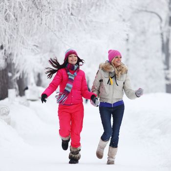 two winter women run by snow frosted alley