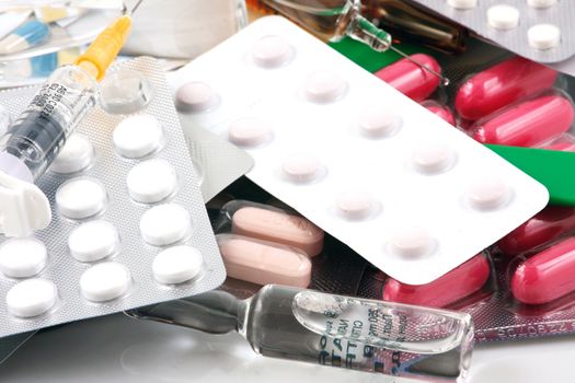 Pills of many shapes and colors grouped together.