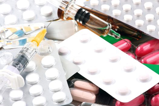 Pills of many shapes and colors grouped together.