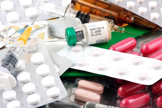 Pills of many shapes and colors grouped together.