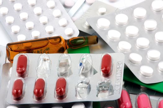 Pills of many shapes and colors grouped together.