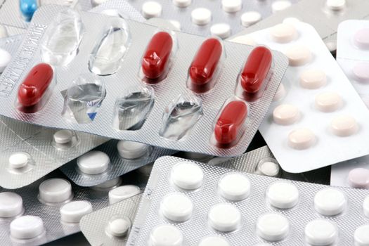 Pills of many shapes and colors grouped together.