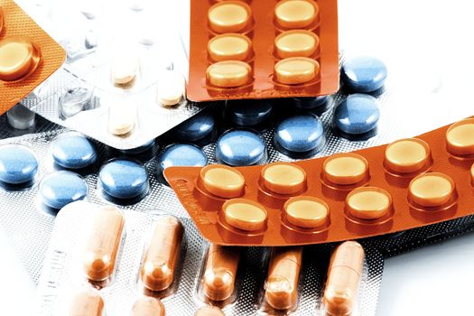 Pills of many shapes and colors grouped together.