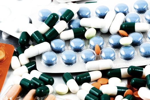 Pills of many shapes and colors grouped together.