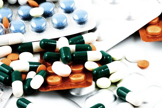 Pills of many shapes and colors grouped together.