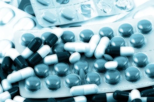 Pills of many shapes and colors grouped together.