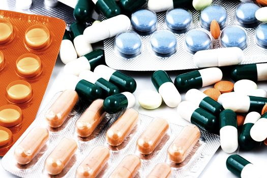 Pills of many shapes and colors grouped together.