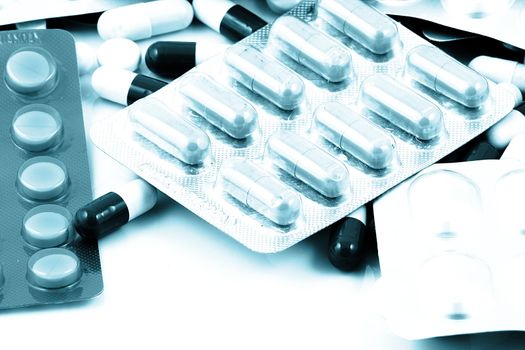 Pills of many shapes and colors grouped together.