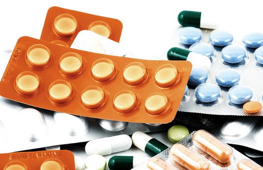 Pills of many shapes and colors grouped together.