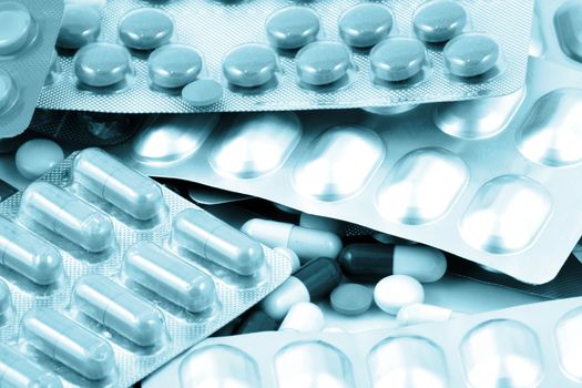 Pills of many shapes and colors grouped together.