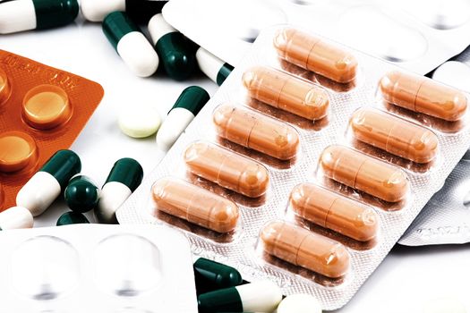 Pills of many shapes and colors grouped together.