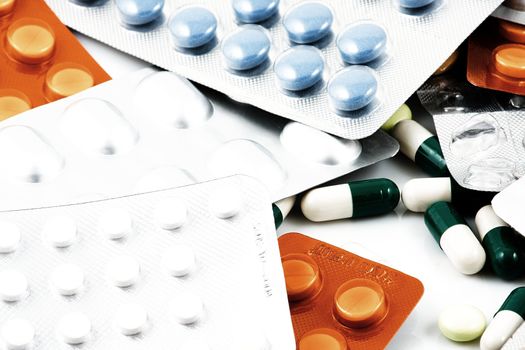 Pills of many shapes and colors grouped together.