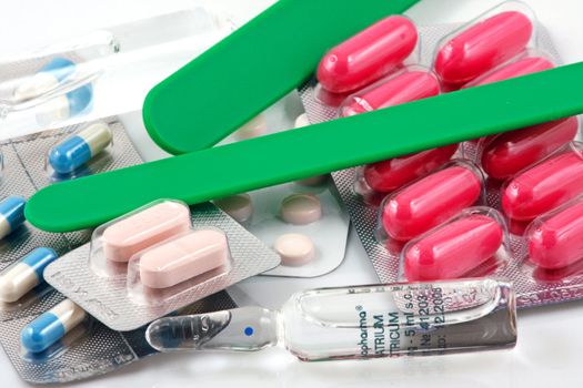 Pills of many shapes and colors grouped together.