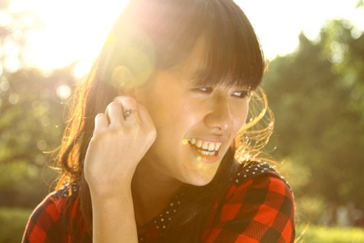 Asian woman smiling under sunshine
