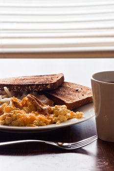 Vertical view of a plate of breakfast food and coffee cup