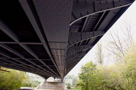 Metal construction of large bridge over river. Architectural design closeup.
