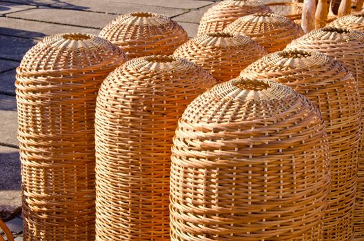 Wicker wooden handmade baskets sold outside in town street fair market.