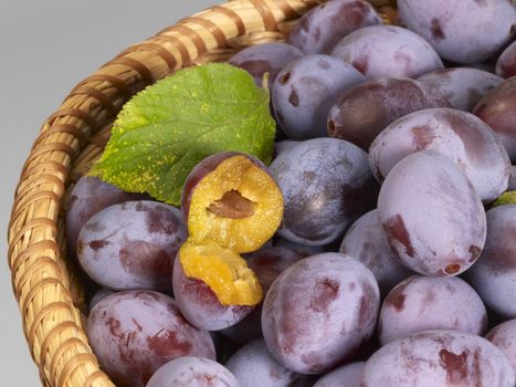 a basket with plums in grey back