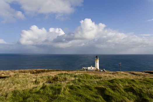 lighthouse at scotlands coast with cloudy sky in background